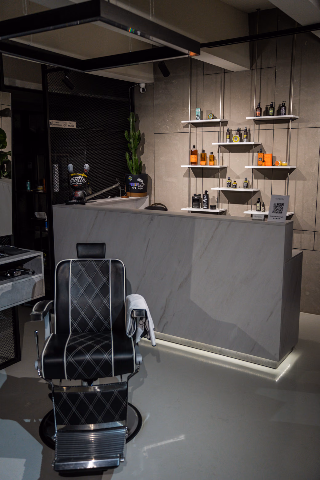 Wnętrze Horizon Barbershop w Krakowie: fotel barberski i lada z kosmetykami